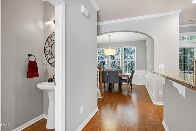 5809 Cameo Glass Way, Raleigh, NC 27612 - hallway with arched walkways, ornamental molding, wood finished floors, healthy amount of natural light, and a wainscoted wall