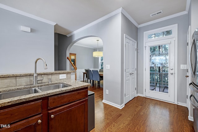 5809 Cameo Glass Way, Raleigh, NC 27612 - kitchen featuring wood finished floors, arched walkways, light stone counters, ornamental molding, and freestanding refrigerator