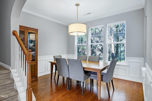 5809 Cameo Glass Way, Raleigh, NC 27612 - dining area with arched walkways, dark wood-type flooring, stairway, ornamental molding, and a wainscoted wall