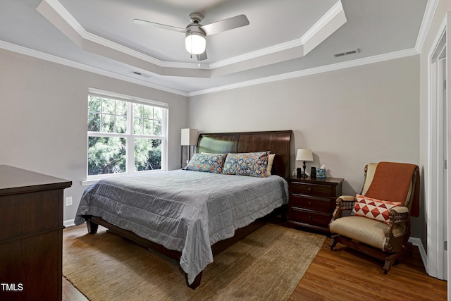 5809 Cameo Glass Way, Raleigh, NC 27612 - bedroom with a tray ceiling, wood finished floors, ornamental molding, and ceiling fan