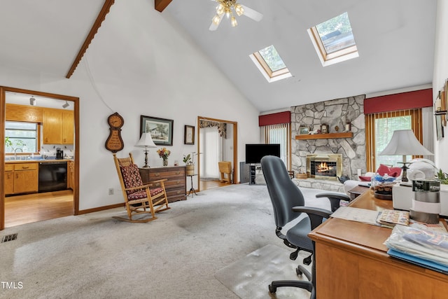 128 Chris Ct, Garner, NC 27529 - office area with light carpet, high vaulted ceiling, a fireplace, a skylight, and ceiling fan