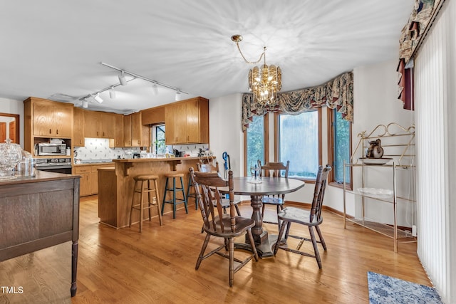 128 Chris Ct, Garner, NC 27529 - dining room with rail lighting, a chandelier, and light wood-type flooring