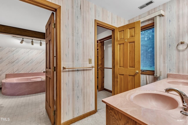 128 Chris Ct, Garner, NC 27529 - bathroom featuring double vanity, a garden tub, and track lighting