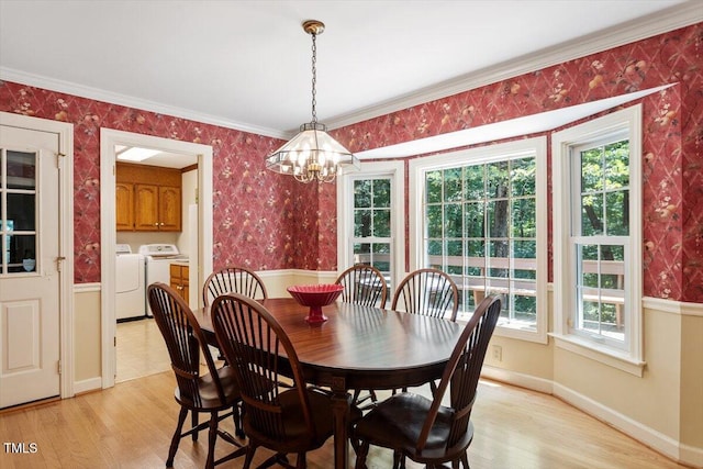 8704 Mill House Ln, Bahama, NC 27503 - dining room with separate washer and dryer, wallpapered walls, a chandelier, light wood-type flooring, and crown molding
