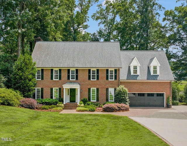 1820 Hunting Ridge Rd, Raleigh, NC 27615 - colonial home featuring concrete driveway, brick siding, a front lawn, and a chimney