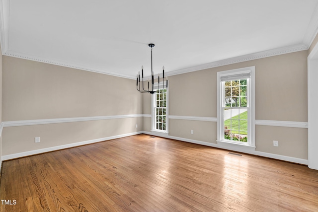 1820 Hunting Ridge Rd, Raleigh, NC 27615 - empty room featuring a chandelier, plenty of natural light, ornamental molding, and wood finished floors