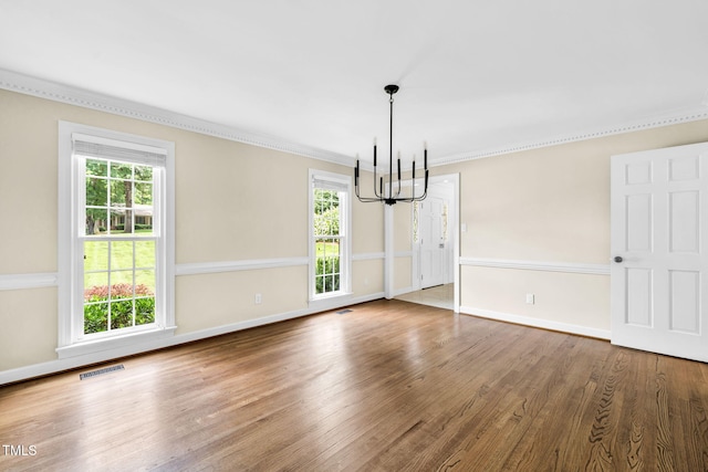 1820 Hunting Ridge Rd, Raleigh, NC 27615 - unfurnished dining area featuring a chandelier, crown molding, healthy amount of natural light, and wood finished floors