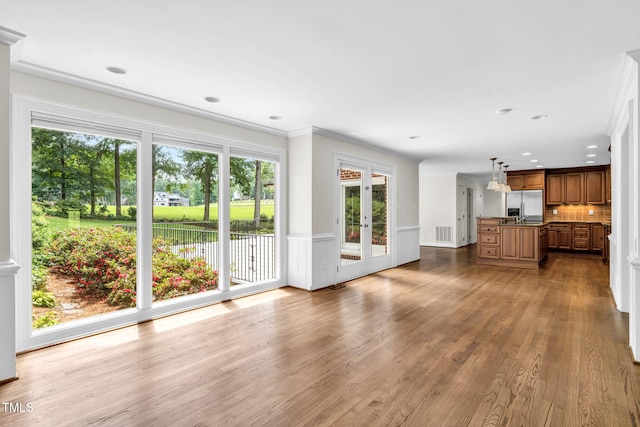 1820 Hunting Ridge Rd, Raleigh, NC 27615 - unfurnished living room with wood finished floors, a wainscoted wall, recessed lighting, and french doors