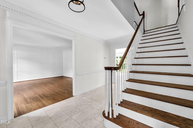 1820 Hunting Ridge Rd, Raleigh, NC 27615 - stairway featuring ornamental molding, wood finished floors, and a decorative wall