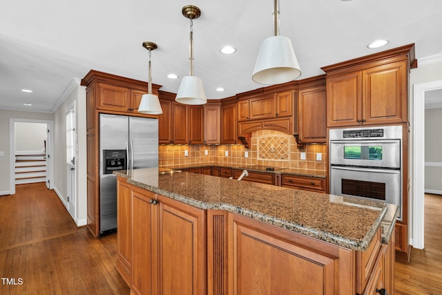 1820 Hunting Ridge Rd, Raleigh, NC 27615 - kitchen featuring appliances with stainless steel finishes, brown cabinetry, ornamental molding, dark wood-type flooring, and decorative backsplash