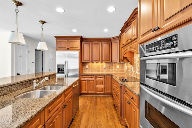 1820 Hunting Ridge Rd, Raleigh, NC 27615 - kitchen featuring stainless steel appliances, brown cabinets, light wood-style floors, decorative light fixtures, and recessed lighting