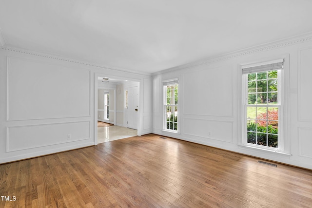 1820 Hunting Ridge Rd, Raleigh, NC 27615 - spare room with a decorative wall, healthy amount of natural light, crown molding, and wood finished floors