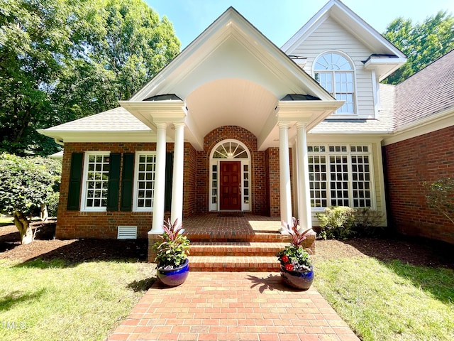 21 Covington Ln, Durham, NC 27712 - view of exterior entry with brick siding, a shingled roof, covered porch, and a lawn