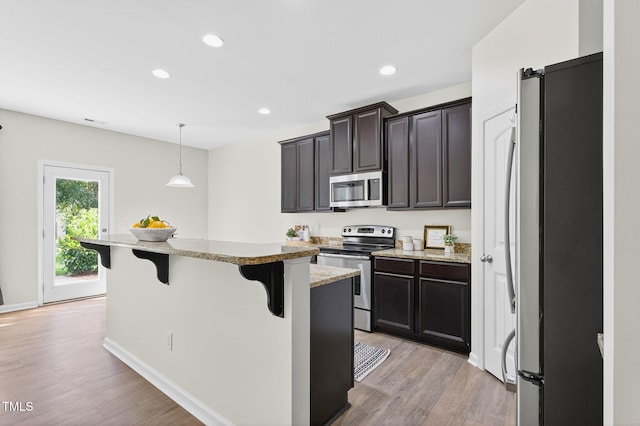 4520 Middletown Dr, Wake Forest, NC 27587 - kitchen featuring appliances with stainless steel finishes, a breakfast bar area, light wood-type flooring, recessed lighting, and a kitchen island
