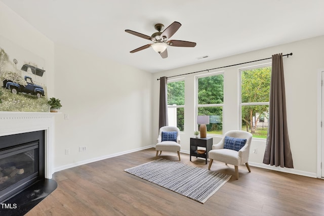 4520 Middletown Dr, Wake Forest, NC 27587 - living area featuring wood finished floors, a glass covered fireplace, and a ceiling fan