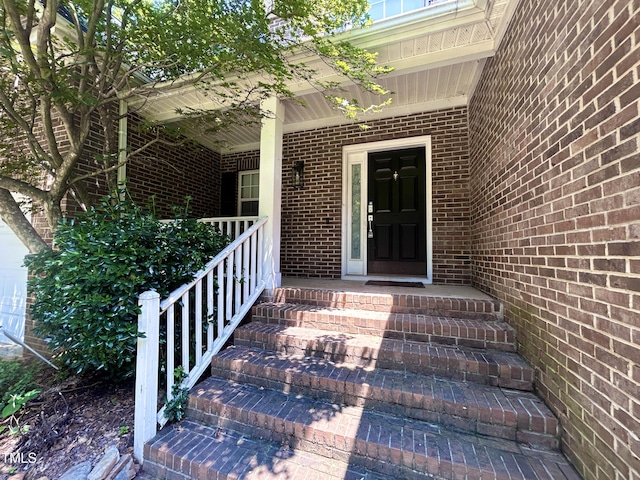 310 New Parkside Dr, Chapel Hill, NC 27516 - view of exterior entry featuring brick siding and a porch