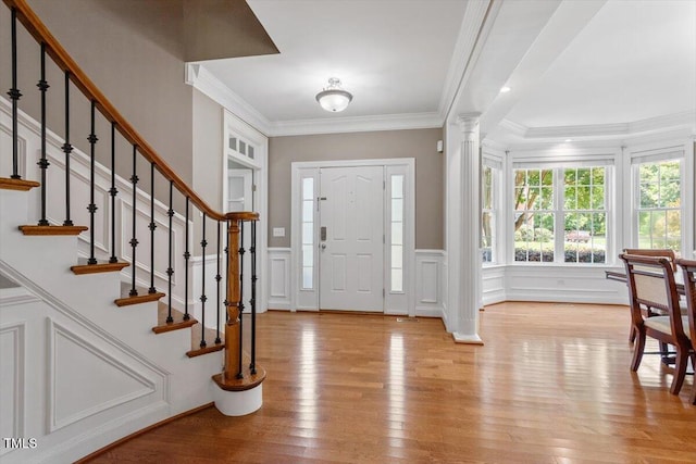 7804 Percussion Dr, Apex, NC 27539 - entrance foyer with ornate columns, light wood-type flooring, stairway, crown molding, and wainscoting