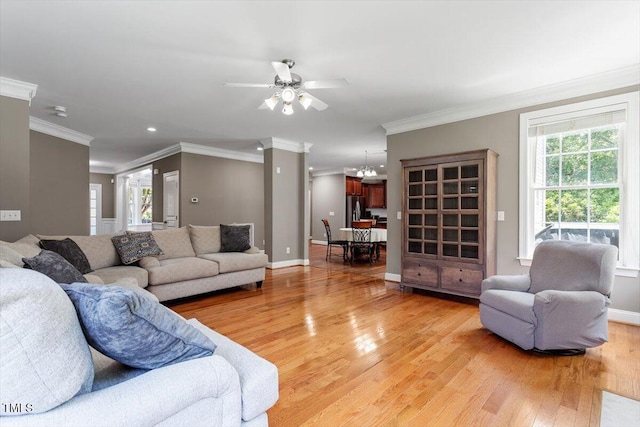 7804 Percussion Dr, Apex, NC 27539 - living room featuring light wood-style floors, crown molding, a ceiling fan, recessed lighting, and a chandelier