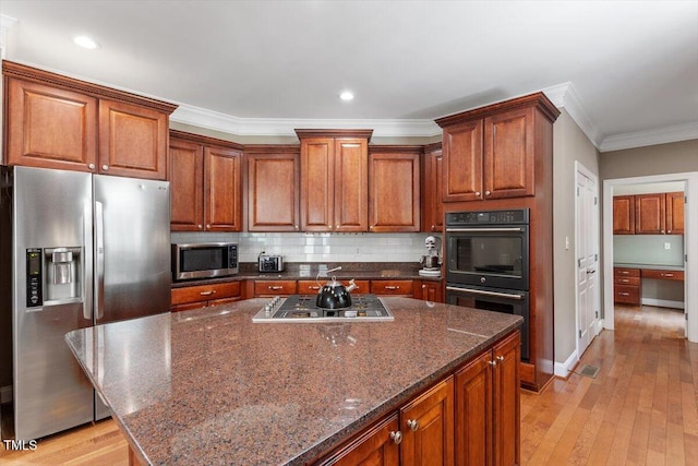 7804 Percussion Dr, Apex, NC 27539 - kitchen with stainless steel appliances, crown molding, light wood-style flooring, backsplash, and a center island