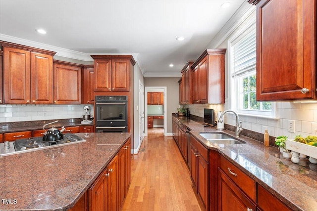 7804 Percussion Dr, Apex, NC 27539 - kitchen with stainless steel gas stovetop, light wood finished floors, ornamental molding, tasteful backsplash, and dark stone counters