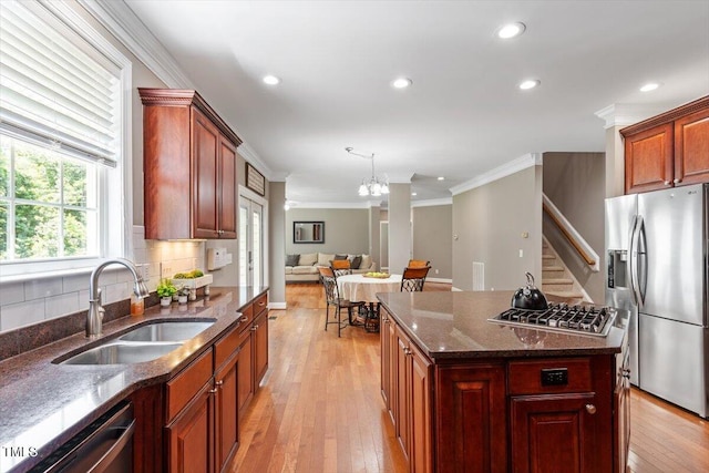 7804 Percussion Dr, Apex, NC 27539 - kitchen with appliances with stainless steel finishes, crown molding, decorative backsplash, light wood-type flooring, and open floor plan