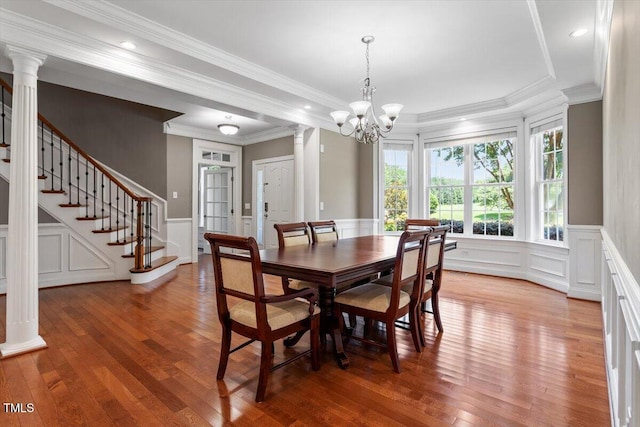 7804 Percussion Dr, Apex, NC 27539 - dining room featuring light wood finished floors, stairs, a decorative wall, a chandelier, and a tray ceiling
