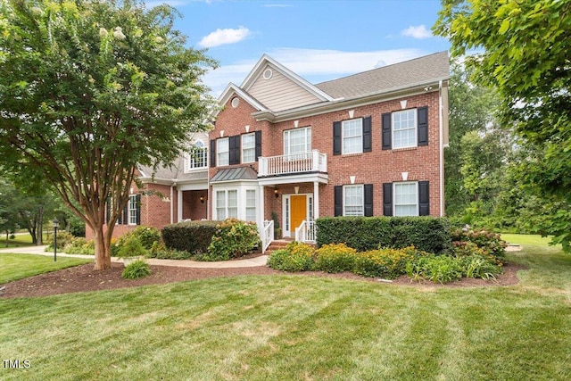 7804 Percussion Dr, Apex, NC 27539 - colonial house with brick siding, a front lawn, and a balcony
