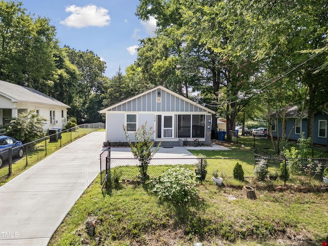 304 Spring St, Durham, NC 27703 - rear view of property with board and batten siding, driveway, and a sunroom