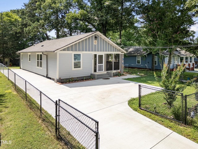 304 Spring St, Durham, NC 27703 - view of front of house with board and batten siding, concrete driveway, roof with shingles, and a fenced backyard