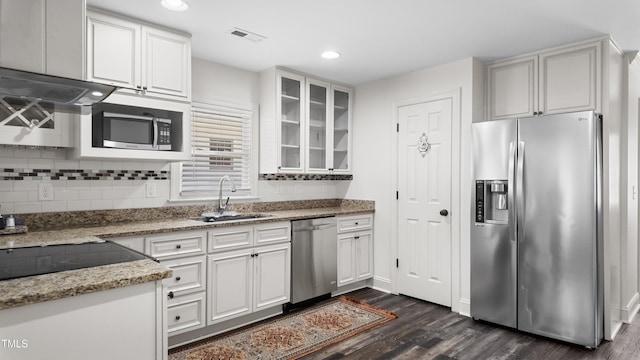 304 Spring St, Durham, NC 27703 - kitchen with stainless steel appliances, dark wood-style flooring, backsplash, white cabinetry, and recessed lighting
