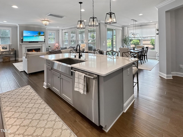 2438 Braxton Wood Ln, Apex, NC 27523 - kitchen featuring dishwasher, recessed lighting, ornamental molding, a kitchen island with sink, and a lit fireplace