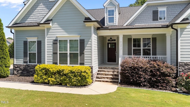 4125 Olde Judd Dr, Willow Springs, NC 27592 - view of front of property featuring covered porch, roof with shingles, stone siding, and a front yard