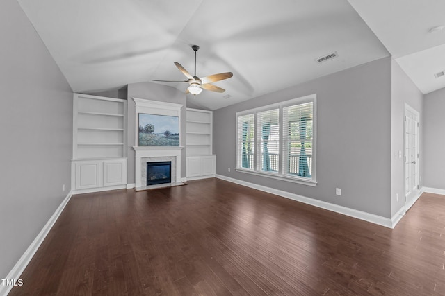 4125 Olde Judd Dr, Willow Springs, NC 27592 - unfurnished living room featuring a ceiling fan, vaulted ceiling, dark wood finished floors, a glass covered fireplace, and built in shelves