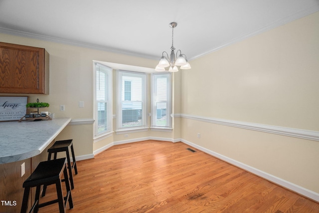 1010 Oakgrove Dr, Knightdale, NC 27545 - unfurnished dining area with a chandelier, ornamental molding, and light wood-type flooring