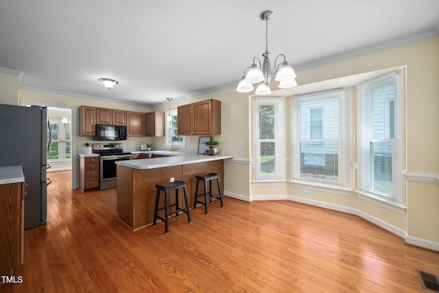1010 Oakgrove Dr, Knightdale, NC 27545 - kitchen featuring electric range, freestanding refrigerator, black microwave, a peninsula, and a chandelier