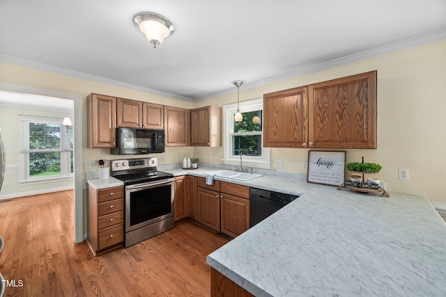 1010 Oakgrove Dr, Knightdale, NC 27545 - kitchen with black appliances, brown cabinetry, wood finished floors, light countertops, and ornamental molding