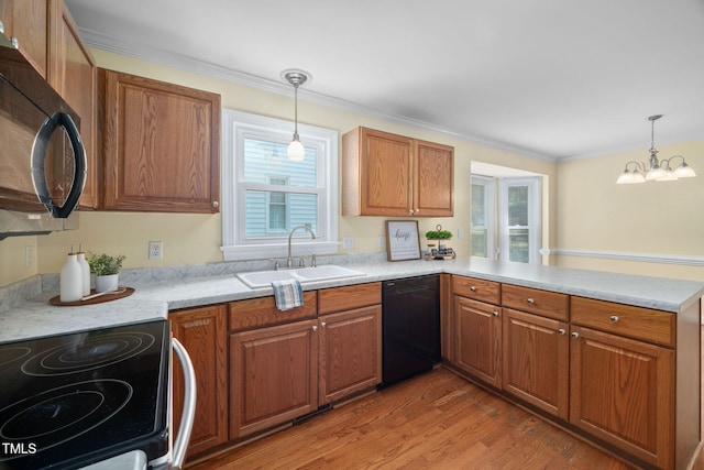 1010 Oakgrove Dr, Knightdale, NC 27545 - kitchen with black appliances, a peninsula, light countertops, brown cabinets, and crown molding