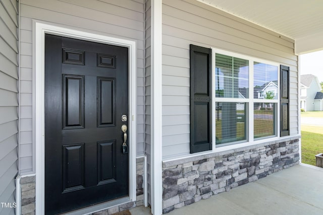 3206 Dandelion Dr, Grimesland, NC 27837 - doorway to property featuring stone siding and covered porch
