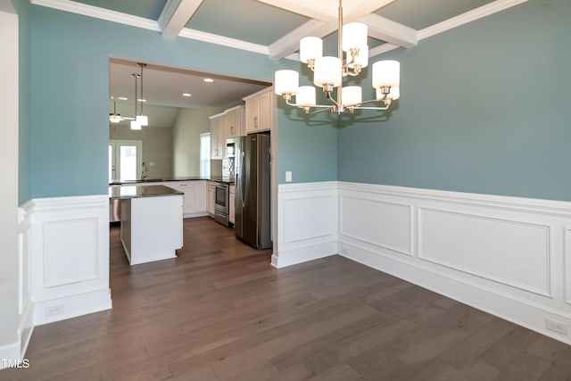 3206 Dandelion Dr, Grimesland, NC 27837 - kitchen featuring stainless steel appliances, a chandelier, beam ceiling, dark countertops, and a wainscoted wall