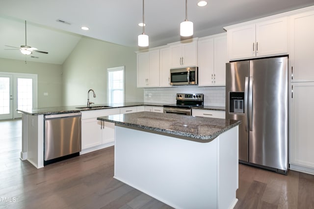 3206 Dandelion Dr, Grimesland, NC 27837 - kitchen featuring appliances with stainless steel finishes, a peninsula, dark wood finished floors, vaulted ceiling, and a center island