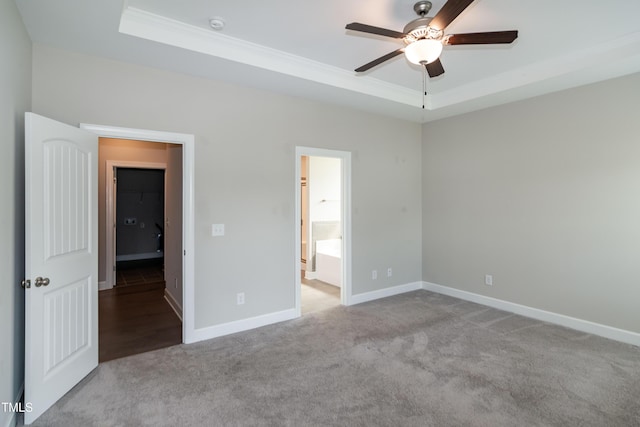 3206 Dandelion Dr, Grimesland, NC 27837 - unfurnished bedroom featuring crown molding, a raised ceiling, carpet flooring, connected bathroom, and a ceiling fan
