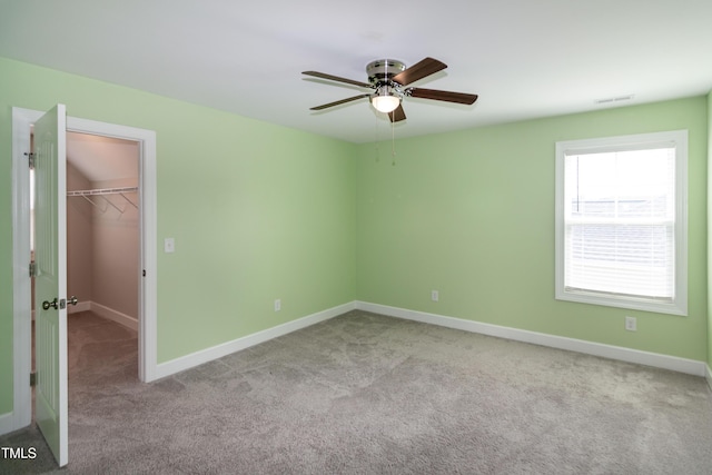 3206 Dandelion Dr, Grimesland, NC 27837 - unfurnished bedroom with carpet floors, a spacious closet, a closet, and a ceiling fan