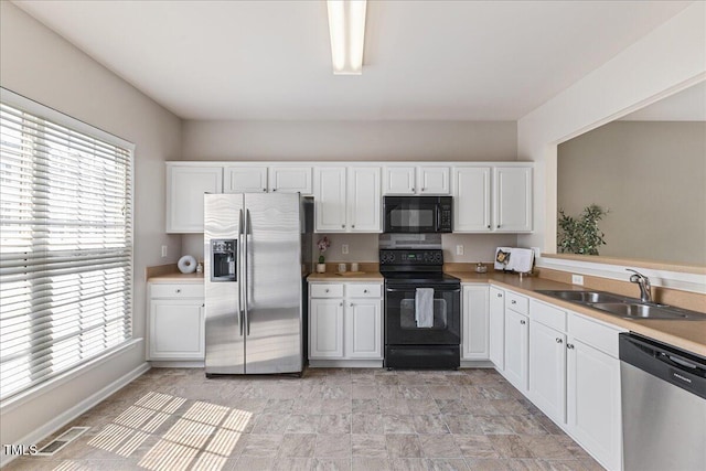 309 Ruby Walk Dr, Morrisville, NC 27560 - kitchen featuring black appliances, white cabinets, and light countertops