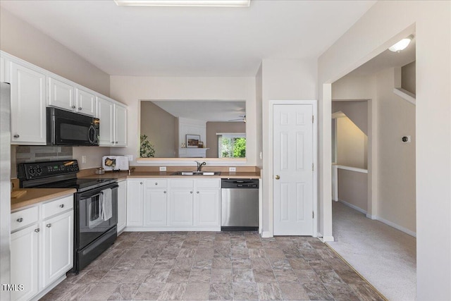 309 Ruby Walk Dr, Morrisville, NC 27560 - kitchen featuring black appliances, white cabinetry, stone finish floors, and light countertops