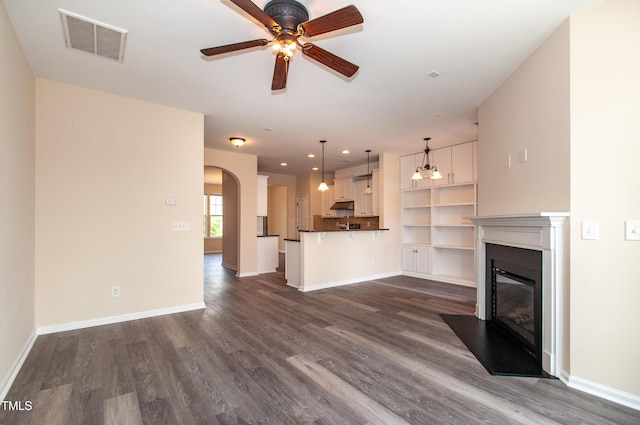 10119 Glen Autumn Rd, Raleigh, NC 27617 - unfurnished living room with ceiling fan, dark wood-type flooring, arched walkways, a fireplace with flush hearth, and recessed lighting