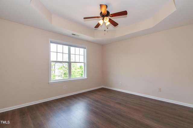 10119 Glen Autumn Rd, Raleigh, NC 27617 - unfurnished room featuring a raised ceiling, dark wood-style flooring, and ceiling fan