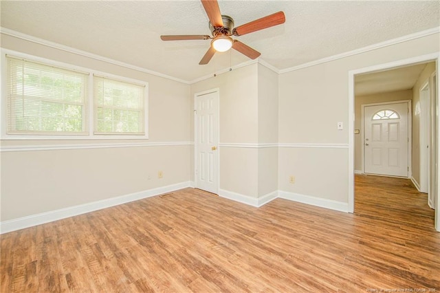 3211 Blossom Rd, Fayetteville, NC 28306 - spare room with light wood-style flooring, a textured ceiling, ceiling fan, and crown molding