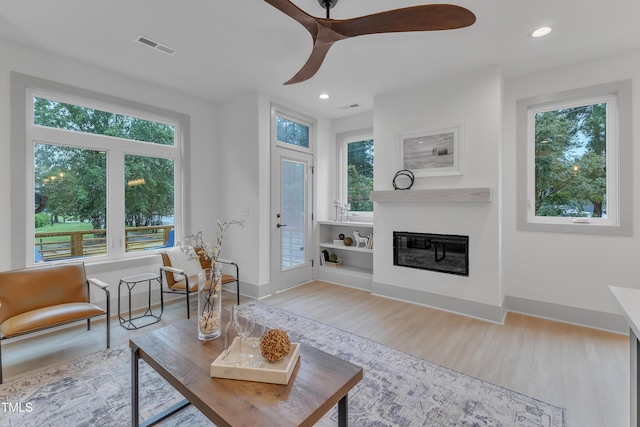 1000 Addison Pl Unit 101, Raleigh, NC 27610 - living area featuring wood finished floors, plenty of natural light, a glass covered fireplace, and recessed lighting