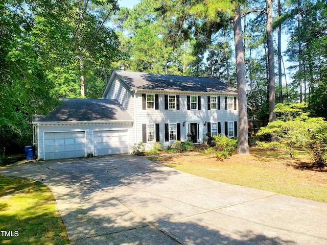 6115 Winthrop Dr, Raleigh, NC 27612 - colonial house with concrete driveway, a garage, and view of scattered trees