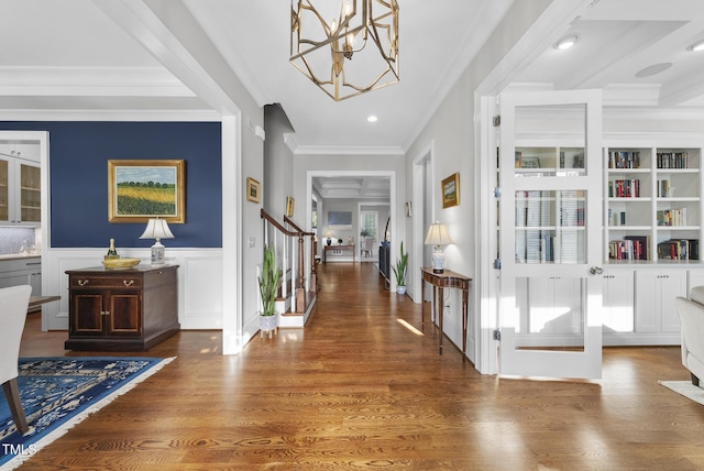 2153 Princeville Dr, Apex, NC 27523 - foyer entrance with a chandelier, ornamental molding, stairway, wood finished floors, and a wainscoted wall